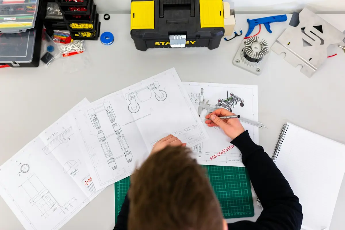 Workbench with tools and plans in a small manufacturing shop